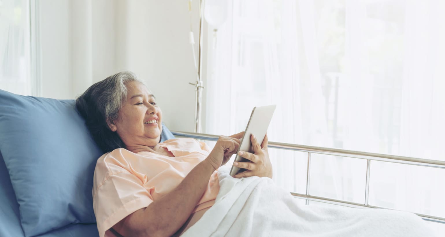 Elderly senior woman patients in hospital bed patients using smart phone call to descendant relatives feel happiness
